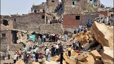 Egyptian residence look for victims following a massive rock slide which buried many dwellings at an Egyptian shanty town 