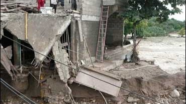 Residents stand on the second floor of a house damaged by Hurricane Ike in Cabaret, Haiti 