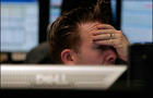 Trader reacts to early market moves on the London Stock Exchange and the FTSE100 index at CMC Markets in London 