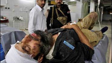 A Pakistani police officer injured in a bombing in the Dir region, is brought to a local hospital in Peshawar 