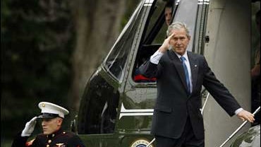 President Bush returns a salute before boarding Marine One helicopter on the South Lawn of the White House 