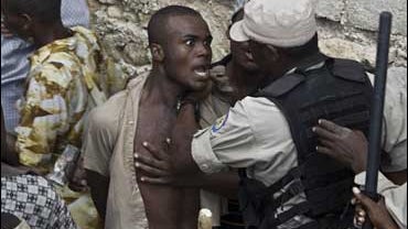 A relative of a victim argues with police officers at the site where a school collapsed in Petionville, Haiti on Nov. 9, 2008. Haitian police were holding the owner of the school that collapsed, killing at least 88 people and setting off a desperate searc 