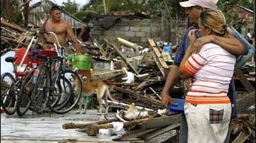 Residents stand among debris from Hurricane Paloma in Santa Cruz del Sur, Cuba 