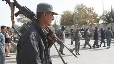 Afghan soldiers stand guard after suicide bombing kills six at government office. 