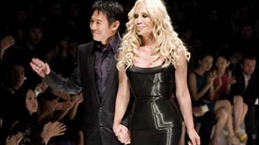 Fashion designer Donatella Versace, right, walks with action star Jet Li after the Versace One Charity Gala fashion show in Beijing, China, Thursday, Nov. 13, 2008. 