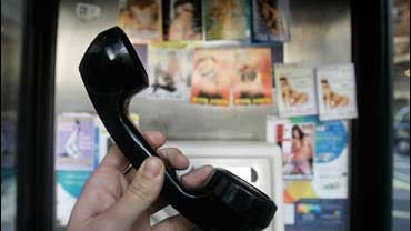 Prostitutes' calling cards in phone booth. 