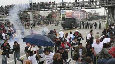 Clients of the investment company DMG run from the tear gas fired by police as they protest in Bogota 