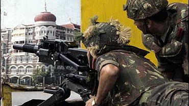 Taj Mahal Hotel, and aim a grenade launcher at a part of the facade of the Taj Mahal Hotel, unseen, in Mumbai, India, 