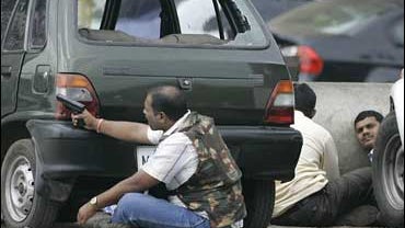 Members of anti-terrorist squad take position during an engagement with suspected militants outside the Taj Mahal Hotel in Mumbai, India, Nov. 28, 2008. 