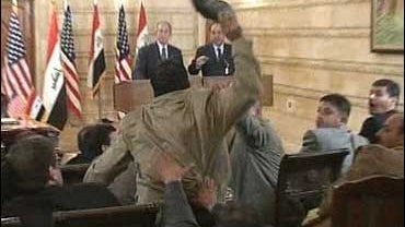 A man throws a shoe at U.S. President George W. Bush, background, during a news conference 
