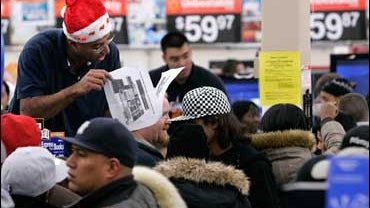 Wal-Mart employee Jose Sanchez, top left, of North Bergen, N.J., looks up the location of a sale item for a customer at the Wal-Mart store in Secaucus, N.J. on Nov. 28, 2008. Wal-Mart Stores Inc. on Thursday, Dec. 4 said November same-store sales rose 3.4 