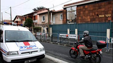 A police car is parked in front of the synagogue in Toulouse, southwestern France Tuesday Jan. 6, 2009 after a burning car was rammed into the synagogue's door on Monday. 