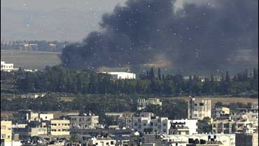 Smoke rises from an Israeli bombardment as leaflets dropped by Israeli aircraft fly in the air over Gaza City 