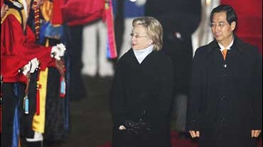 U.S. Secretary of State Hillary Rodham Clinton inspects honor guards as Han Duck-soo, South Koran ambassador to the United States,  looks on upon her arrival at Seoul military airport in Seongnam 