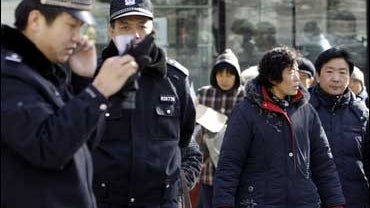 Police keep watch over a group of protesters outside a government petition office in Beijing 