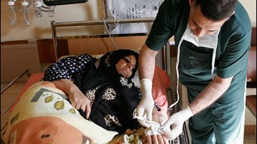 An Iraqi woman is treated after she was wounded in a suicide bombing attack in Abu Ghraib, in Baghdad, Iraq, Tuesday, March 10, 2009. 
