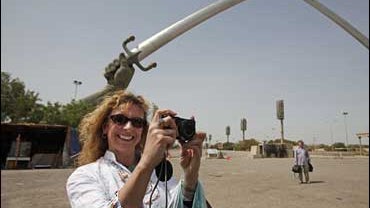 Tina Townsend Greaves, from Yorkshire, U.K., takes a photo during a visit to the crossed swords monument in the Green Zone in Baghdad 