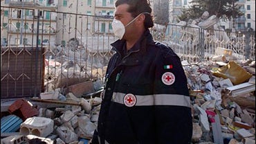 A Red Cross member stands amidst rubbles in L'Aquila, central Italy, Wednesday, April 8, 2009. 