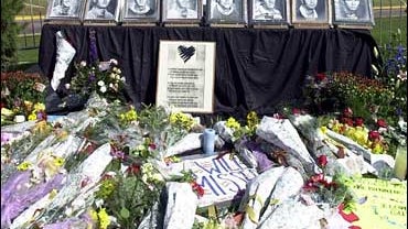 A memorial to the University of Wyoming Athletic Department in Laramie, Wyo., is adorned with flowers and photos of the eight deceased members of the cross country track team on Tuesday, Sept. 18, 2001. 