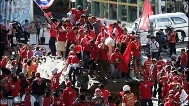Anti-government demonstrators cheer after taking over a Thai Army armored personnel carrier Sunday, April 12, 2009, in Bangkok, Thailand. 