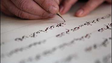 Palestinian calligrapher Yasser Abu Saymeh works in his shop in the West Bank town of Bethlehem. Abu Saymeh is a devout Muslim, but has dedicated the past two months to Christian art: he's writing the Gospel of Luke in ornate Arabic script 