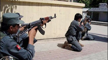 Afghan security personnel aim their weapons during a clash with militants following attacks on government buildings in Khost 