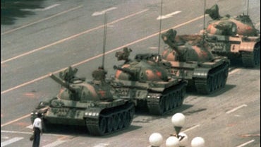 A Chinese man stands alone to block a line of tanks heading east on Beijing's Cangan Blvd. in Tiananmen Square on June 5, 1989. The man, calling for an end to the recent violence and bloodshed against pro-democracy demonstrators, was pulled away by bystan 
