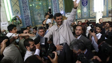 Surrounded by his bodyguards Iran's President Mahmoud Ahmadinejad, greets his supporters before casting his ballot in the Presidential elections in Tehran, Iran, Friday June, 12, 2009. 