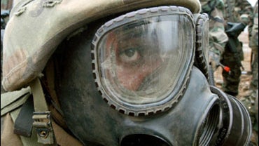 A U.S. Army soldier of the 4th Chemical Company, wearing a gas mask, listens to explanations before their chemical attack drill, near the demilitarized zone between the two Koreas in Yeoncheon city, Wednesday morning, Feb. 26, 2003. 