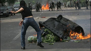 Supporters of opposition leader Mir Hossien Mousavi set fire to a barricade as they hurl stones during a protest in Tehran on Saturday June, 20, 2009. 