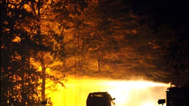Firefighters, right, hose down the blaze that engulfed the home of Richard Shenkman on Tuesday, July 7, 2009 in South Windsor, Connecticut. Shenkman who had held his ex-wife hostage there after kidnapping her in Hartford on Tuesday morning finally surrend 