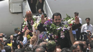 Iranian diplomats Abbas Hatami Kasavand, foreground, and Mohsen Bagheri, are welcomed upon their arrival at Tehran's Mehrabad airport in Tehran, Iran, Sunday, July 12, 2009. 