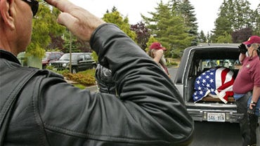 Members of the Patriot Guard salute the flag-draped casket of Brian N. Bradshaw, after it was loaded into a hearse at St. John's Bosco Church in Lakewood, Wash. on Monday, July 6, 2009. 