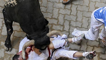 Reveler is gored by the bull ''Ermitano'' during the sixth run of the Miura fighting bulls at San Fermin Fiestas in Pamplona, northern Spain, Sunday, July 12, 2009. 