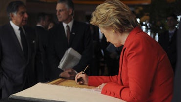 In this photo provided by the United States Information Service, U.S. Secretary of State Hillary Rodham Clinton signs a memorial guest book at the Taj Mahal hotel in Mumbai, India, Saturday, July 18, 2009. 