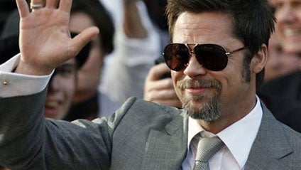 Brad Pitt waves to fans as he  arrives for the German premiere of the movie "Inglourious Basterds" in Berlin,  Tuesday, July 28, 2009. 