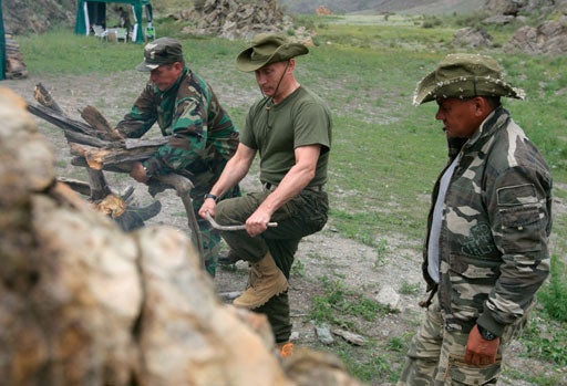 Vladimir Putin breaks a tree branch for a bonfire  