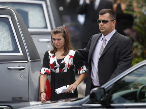 A girl cries as she is escorted past hearses after a funeral Mass at Our Lady of Victory Roman Catholic Church in Floral Park, NY, Thursday, July 30, 2009 to remember five family members killed in a parkway crash. (AP Photo/Seth Wenig) 