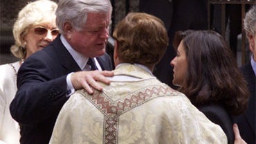 Sen. Edward Kennedy, left, and his wife Victoria, second from right, talk with an unidentified priest outside the Church of St. Thomas More in New York Friday, July 23, 1999 following a quiet Mass to celebrate the lives of John Kennedy Jr. and Carolyn Bes 