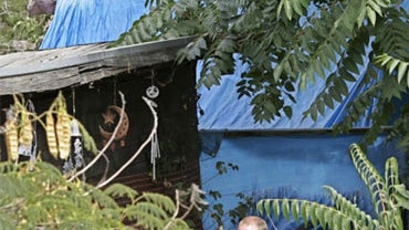 Authorities walk next to shacks in the backyards of a home in Antioch, Calif., Friday, Aug. 28, 2009, where authorities say kidnapped victim Jaycee Lee Dugard lived. The twisted kidnapping case of a woman held captive for 18 years in a secluded backyard c 