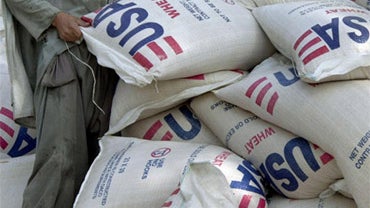 Humanitarian aid worker handles bag of wheat donated by US going to Afghanistan 