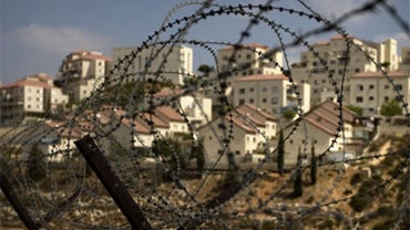 The West Bank Jewish settlement of Beitar Ilit is seen through a barbed wire fence, Friday, Sept. 4, 2009. 