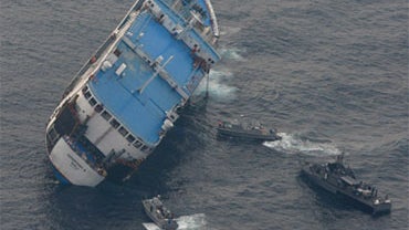 Navy ships approach the tilted Superferry 9 off Zamboanga del Norte province, southern Philippines, Sunday Sept. 6, 2009. 