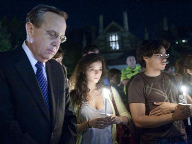 Yale University President Richard C. Levin, left, bows his head in a moment of silence during a candlelight vigil in New Haven, Conn., Monday, Sept 14, 2009. 