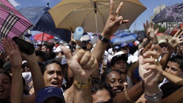 People cheer as they wait for the "Peace Without Borders" concert at the Revolution square in Havana, Sunday, Sept. 20, 2009. the concert is organized by Colombian singer Juanes. 
