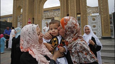 A Sunni Muslim woman kisses her son after Eid prayers outside Abu Hanifa mosque at the first day of Eid al- Fitr prayers in the Azamiyah area of north Baghdad, Iraq, Sunday, Sept. 20, 2009. The three-day Eid al-Fitr holiday marks the end of the holy fasti 