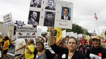 Demonstrators hold up banners as they walk in Pennsylvania Avenue to Capitol Hill in Washington, Saturday, Sept. 12, 2009, during a taxpayer rally. 