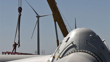 A worker labors on a crane which is used to build wind turbines at a wind farm in Shangyi, Hebei, China. 