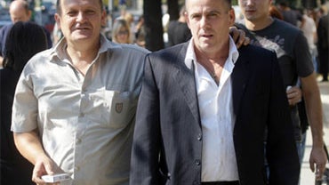 Former Serbian police officers Sreten Popovic, right, and Milos Stojanovic, left, react as they leave special court in Belgrade, Tuesday, Sept. 22, 2009. 