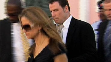 John Travolta, right, exits a Nassau courtroom in the Bahamas after testifying against two men who allegedly tried to extort $25 million from the movie star. During his testimony, Travolta admitted for the first time his son had autism. 